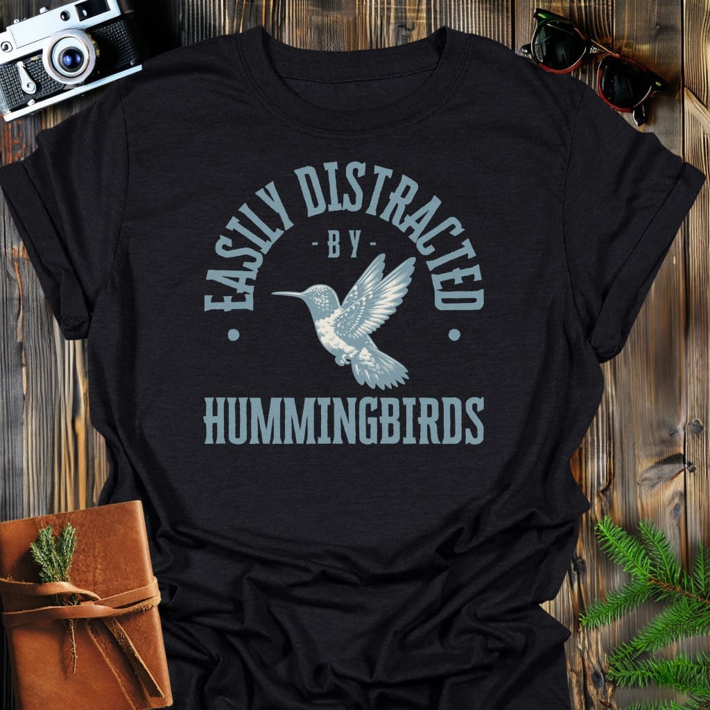 Distracted By Hummingbirds T-Shirt In S / Black Lightweight adventure tee for outdoor lovers Perfect for hiking camping or road trips Made from soft breathable cotton for all-day comfort Ideal for nature lovers and adventurers FAYO Threads outdoor apparel remember Fun Awaits You Outside