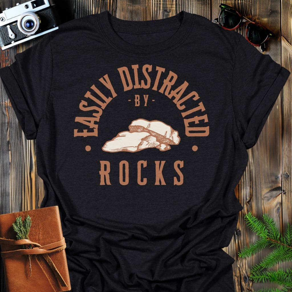 Distracted by Rocks T-Shirt In S / Black Lightweight adventure tee for outdoor lovers Perfect for hiking camping or road trips Made from soft breathable cotton for all-day comfort Ideal for nature lovers and adventurers FAYO Threads outdoor apparel remember Fun Awaits You Outside