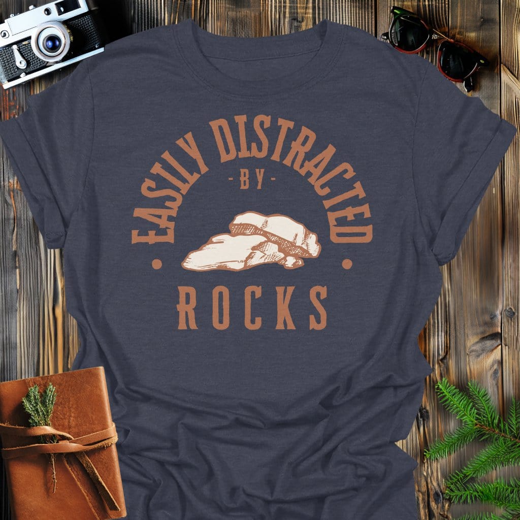 Distracted by Rocks T-Shirt In S / Dark Heather Lightweight adventure tee for outdoor lovers Perfect for hiking camping or road trips Made from soft breathable cotton for all-day comfort Ideal for nature lovers and adventurers FAYO Threads outdoor apparel remember Fun Awaits You Outside
