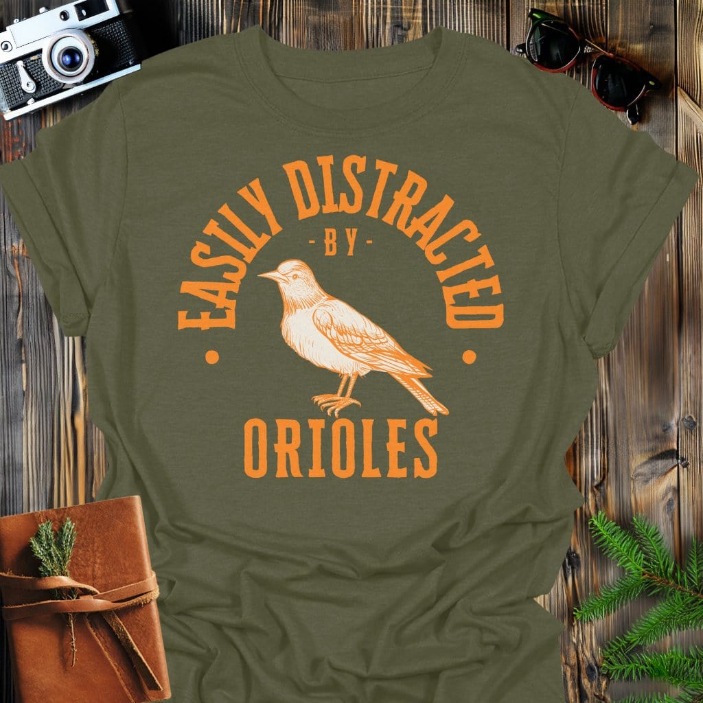 Distracted by Orioles T-Shirt In S / Military Green Lightweight adventure tee for outdoor lovers Perfect for hiking camping or road trips Made from soft breathable cotton for all-day comfort Ideal for nature lovers and adventurers FAYO Threads outdoor apparel remember Fun Awaits You Outside
