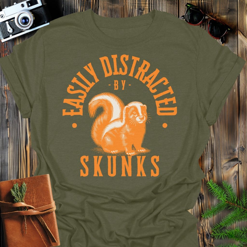 Distracted by Skunks T-Shirt In S / Military Green Lightweight adventure tee for outdoor lovers Perfect for hiking camping or road trips Made from soft breathable cotton for all-day comfort Ideal for nature lovers and adventurers FAYO Threads outdoor apparel remember Fun Awaits You Outside