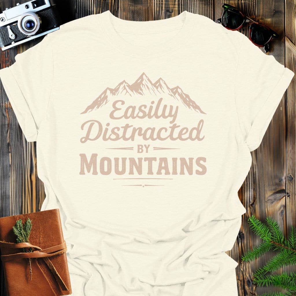 Distracted by Mountains T-Shirt In S / Natural Lightweight adventure tee for outdoor lovers Perfect for hiking camping or road trips Made from soft breathable cotton for all-day comfort Ideal for nature lovers and adventurers FAYO Threads outdoor apparel remember Fun Awaits You Outside