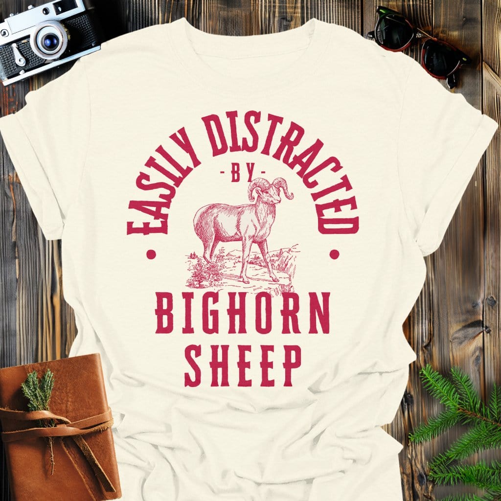 Distracted by Bighorn Sheep T-Shirt In S / Natural Lightweight adventure tee for outdoor lovers Perfect for hiking camping or road trips Made from soft breathable cotton for all-day comfort Ideal for nature lovers and adventurers FAYO Threads outdoor apparel remember Fun Awaits You Outside