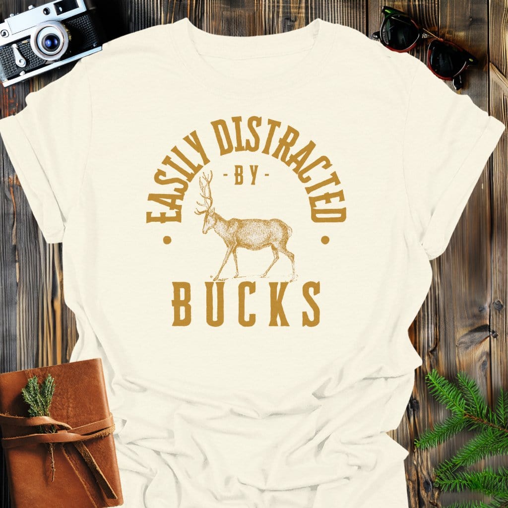 Distracted By Bucks T-Shirt In S / Natural Lightweight adventure tee for outdoor lovers Perfect for hiking camping or road trips Made from soft breathable cotton for all-day comfort Ideal for nature lovers and adventurers FAYO Threads outdoor apparel remember Fun Awaits You Outside