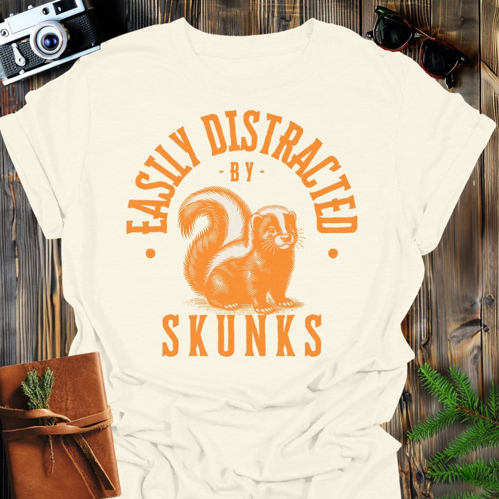 Distracted by Skunks T-Shirt In S / Natural Lightweight adventure tee for outdoor lovers Perfect for hiking camping or road trips Made from soft breathable cotton for all-day comfort Ideal for nature lovers and adventurers FAYO Threads outdoor apparel remember Fun Awaits You Outside