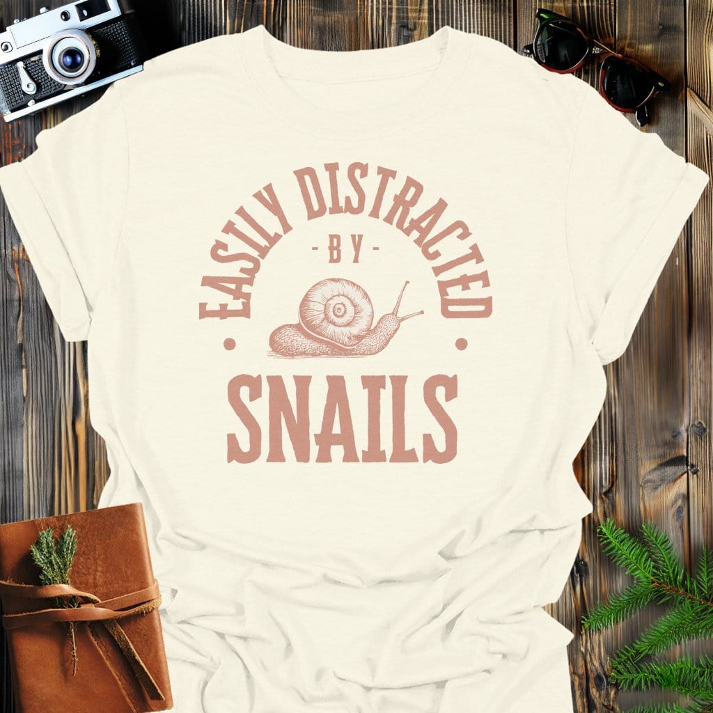 Distracted By Snails T-Shirt In S / Natural Lightweight adventure tee for outdoor lovers Perfect for hiking camping or road trips Made from soft breathable cotton for all-day comfort Ideal for nature lovers and adventurers FAYO Threads outdoor apparel remember Fun Awaits You Outside