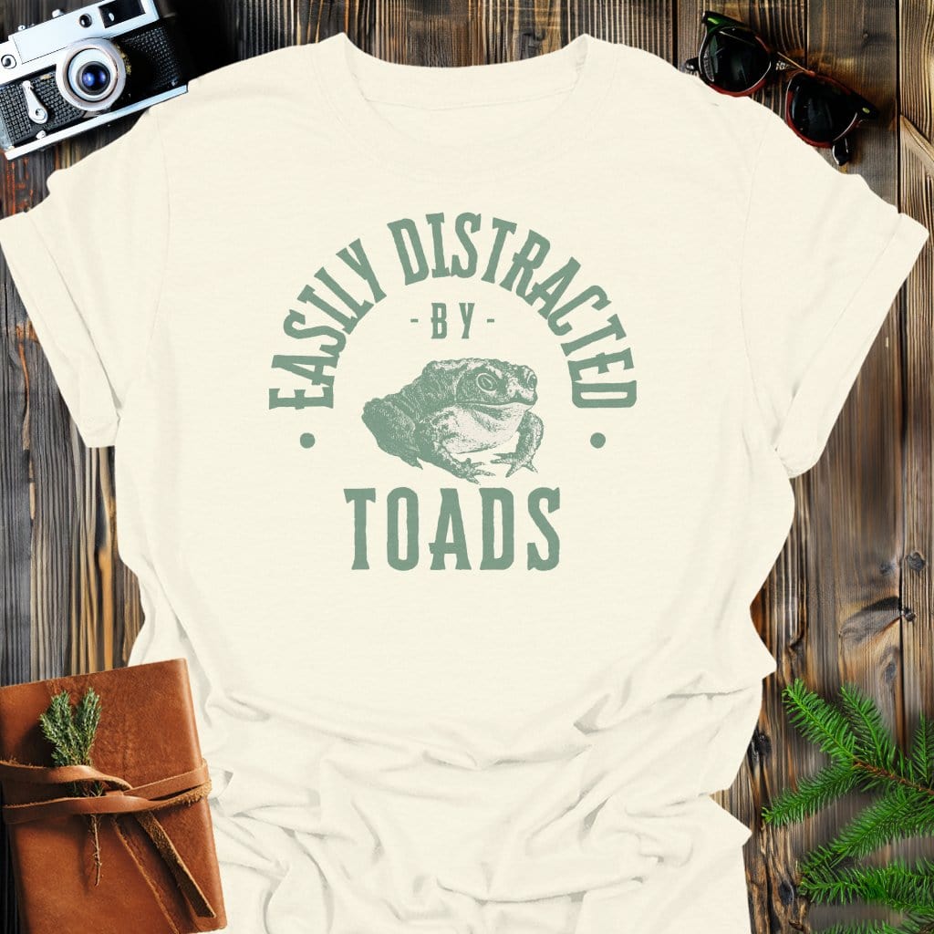 Distracted By Toads T-Shirt In S / Natural Lightweight adventure tee for outdoor lovers Perfect for hiking camping or road trips Made from soft breathable cotton for all-day comfort Ideal for nature lovers and adventurers FAYO Threads outdoor apparel remember Fun Awaits You Outside
