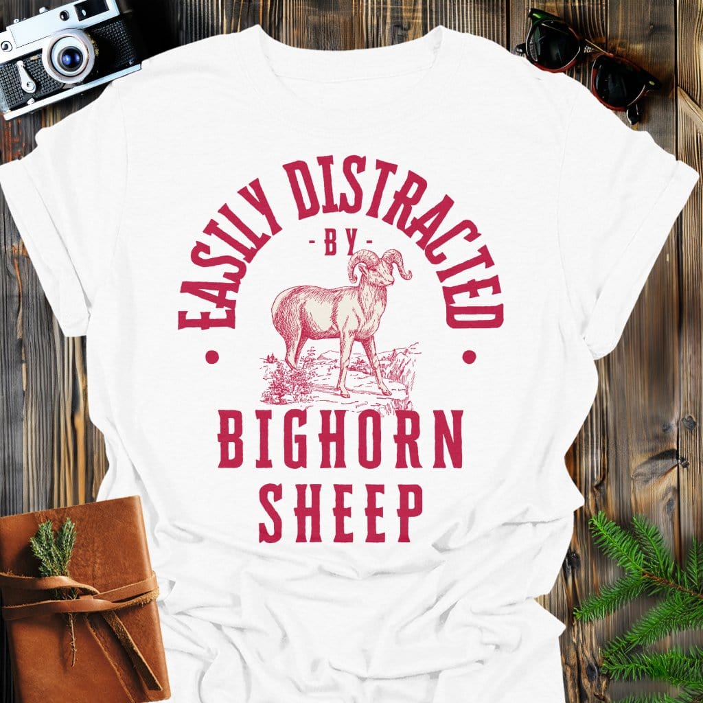 Distracted by Bighorn Sheep T-Shirt In S / White Lightweight adventure tee for outdoor lovers Perfect for hiking camping or road trips Made from soft breathable cotton for all-day comfort Ideal for nature lovers and adventurers FAYO Threads outdoor apparel remember Fun Awaits You Outside