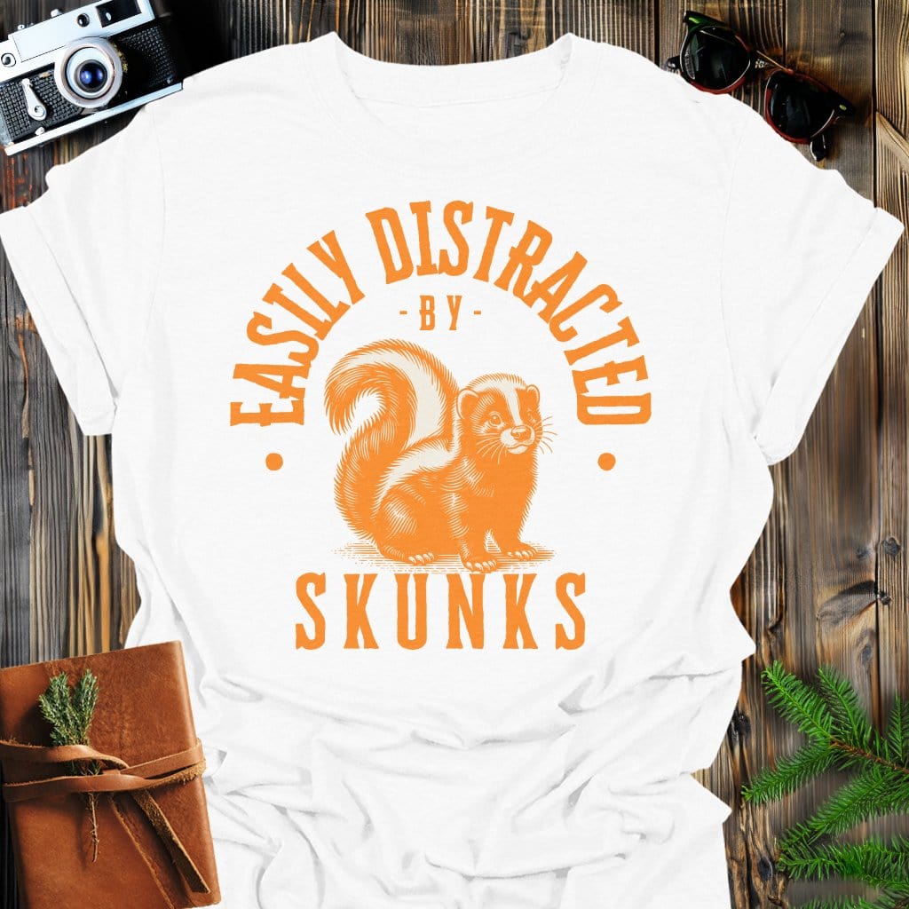 Distracted by Skunks T-Shirt In S / White Lightweight adventure tee for outdoor lovers Perfect for hiking camping or road trips Made from soft breathable cotton for all-day comfort Ideal for nature lovers and adventurers FAYO Threads outdoor apparel remember Fun Awaits You Outside