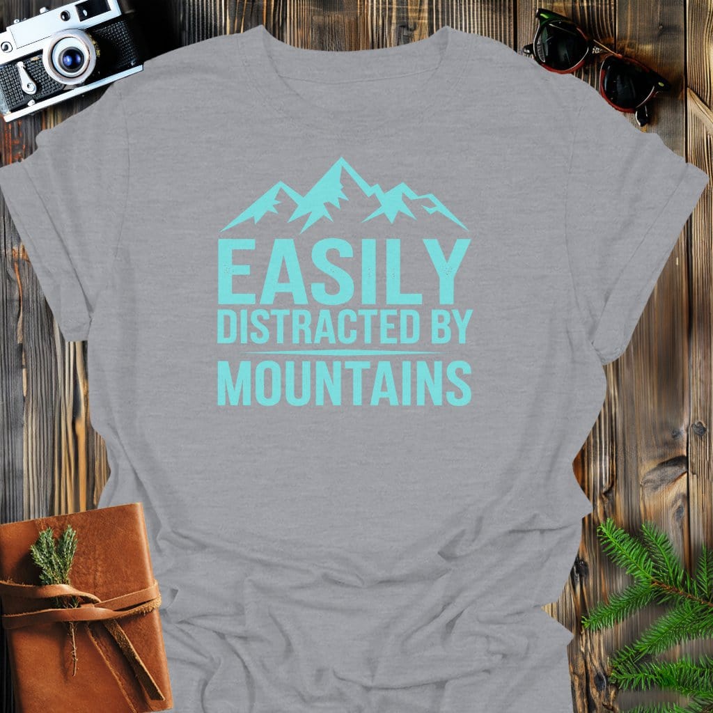 Easily Distracted By Mountains T-Shirt In Sport Grey / S Lightweight adventure tee for outdoor lovers Perfect for hiking camping or road trips Made from soft breathable cotton for all-day comfort Ideal for nature lovers and adventurers FAYO Threads outdoor apparel remember Fun Awaits You Outside