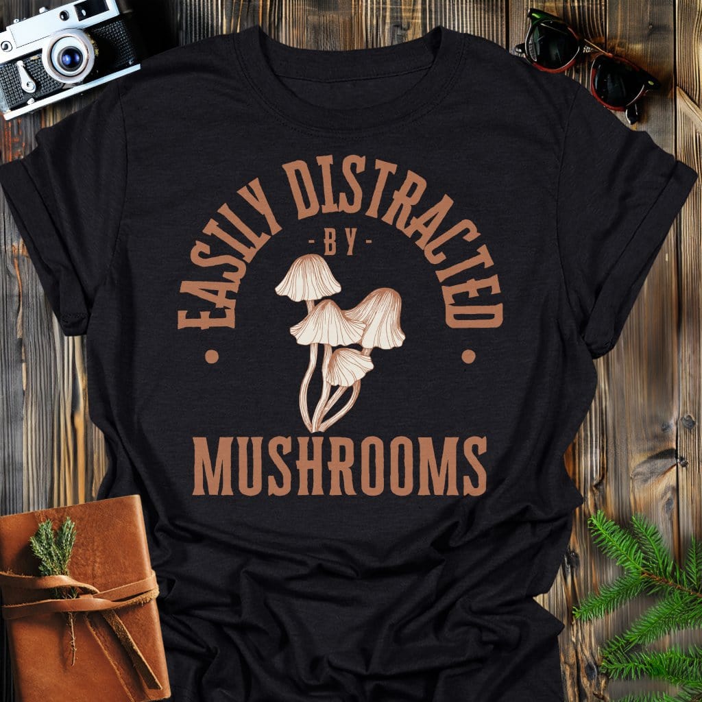 Distracted by Mushrooms T-Shirt In S / Black Lightweight adventure tee for outdoor lovers Perfect for hiking camping or road trips Made from soft breathable cotton for all-day comfort Ideal for nature lovers and adventurers FAYO Threads outdoor apparel remember Fun Awaits You Outside