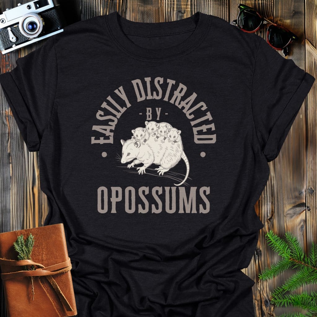 Distracted by Opossums T-Shirt In S / Black Lightweight adventure tee for outdoor lovers Perfect for hiking camping or road trips Made from soft breathable cotton for all-day comfort Ideal for nature lovers and adventurers FAYO Threads outdoor apparel remember Fun Awaits You Outside
