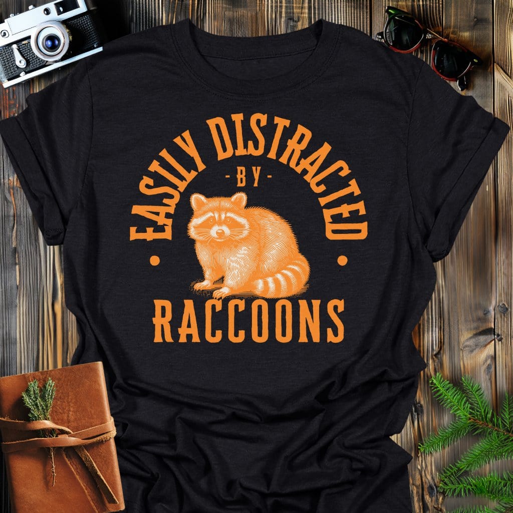 Distracted by Raccoons T-Shirt In S / Black Lightweight adventure tee for outdoor lovers Perfect for hiking camping or road trips Made from soft breathable cotton for all-day comfort Ideal for nature lovers and adventurers FAYO Threads outdoor apparel remember Fun Awaits You Outside