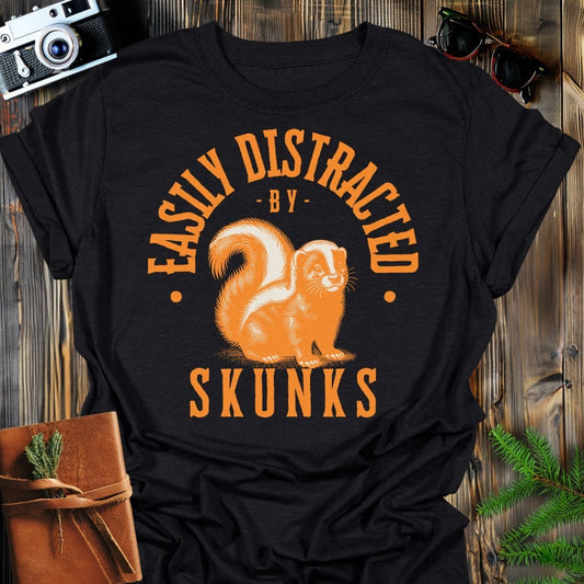 Distracted by Skunks T-Shirt In S / Black Lightweight adventure tee for outdoor lovers Perfect for hiking camping or road trips Made from soft breathable cotton for all-day comfort Ideal for nature lovers and adventurers FAYO Threads outdoor apparel remember Fun Awaits You Outside
