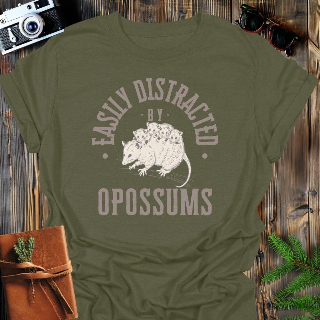 Distracted by Opossums T-Shirt In S / Military Green Lightweight adventure tee for outdoor lovers Perfect for hiking camping or road trips Made from soft breathable cotton for all-day comfort Ideal for nature lovers and adventurers FAYO Threads outdoor apparel remember Fun Awaits You Outside