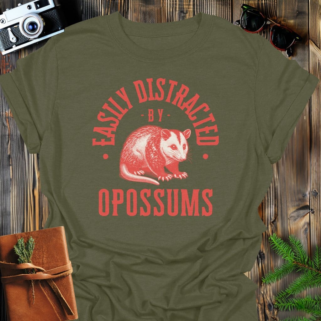 Distracted by Opossums T-Shirt In S / Military Green Lightweight adventure tee for outdoor lovers Perfect for hiking camping or road trips Made from soft breathable cotton for all-day comfort Ideal for nature lovers and adventurers FAYO Threads outdoor apparel remember Fun Awaits You Outside