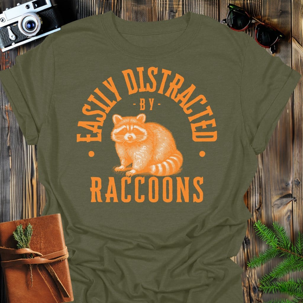 Distracted by Raccoons T-Shirt In S / Military Green Lightweight adventure tee for outdoor lovers Perfect for hiking camping or road trips Made from soft breathable cotton for all-day comfort Ideal for nature lovers and adventurers FAYO Threads outdoor apparel remember Fun Awaits You Outside