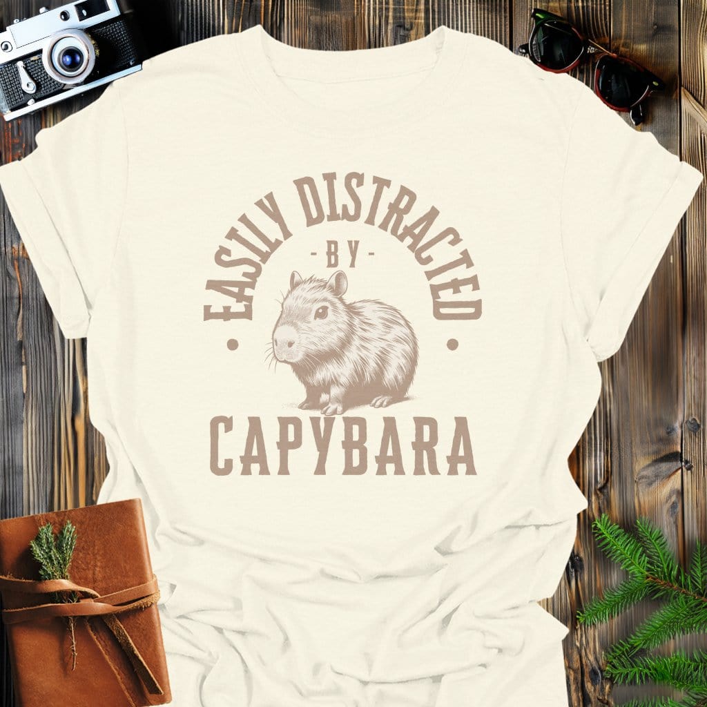 Distracted by Capybara T-Shirt In S / Natural Lightweight adventure tee for outdoor lovers Perfect for hiking camping or road trips Made from soft breathable cotton for all-day comfort Ideal for nature lovers and adventurers FAYO Threads outdoor apparel remember Fun Awaits You Outside
