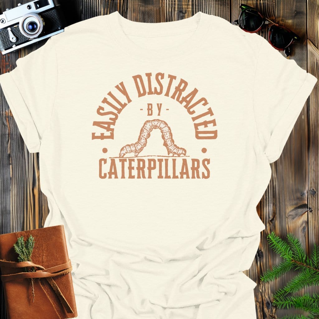 Distracted By Catepillars T-Shirt In S / Natural Lightweight adventure tee for outdoor lovers Perfect for hiking camping or road trips Made from soft breathable cotton for all-day comfort Ideal for nature lovers and adventurers FAYO Threads outdoor apparel remember Fun Awaits You Outside