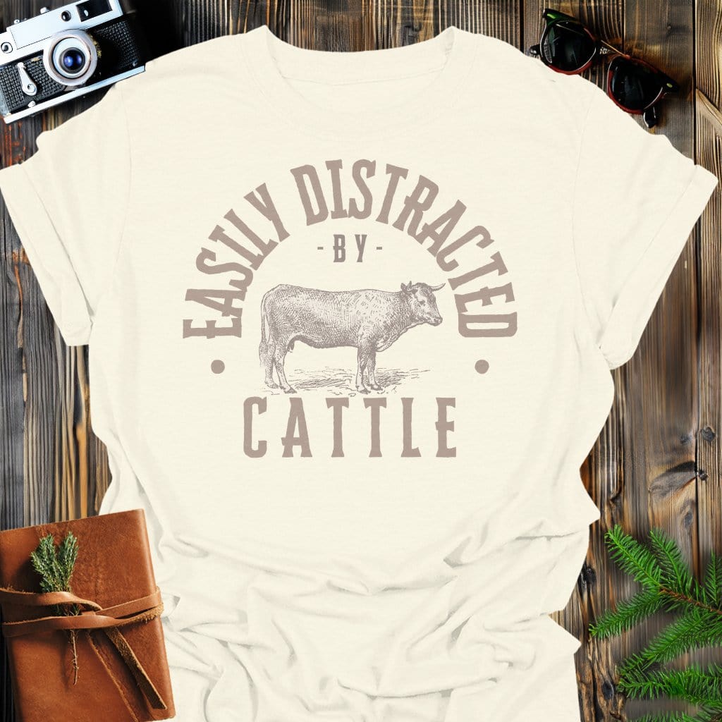 Distracted by Cattle T-Shirt In S / Natural Lightweight adventure tee for outdoor lovers Perfect for hiking camping or road trips Made from soft breathable cotton for all-day comfort Ideal for nature lovers and adventurers FAYO Threads outdoor apparel remember Fun Awaits You Outside