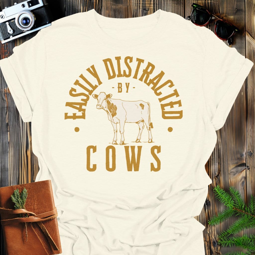 Distracted by Cows T-Shirt In S / Natural Lightweight adventure tee for outdoor lovers Perfect for hiking camping or road trips Made from soft breathable cotton for all-day comfort Ideal for nature lovers and adventurers FAYO Threads outdoor apparel remember Fun Awaits You Outside
