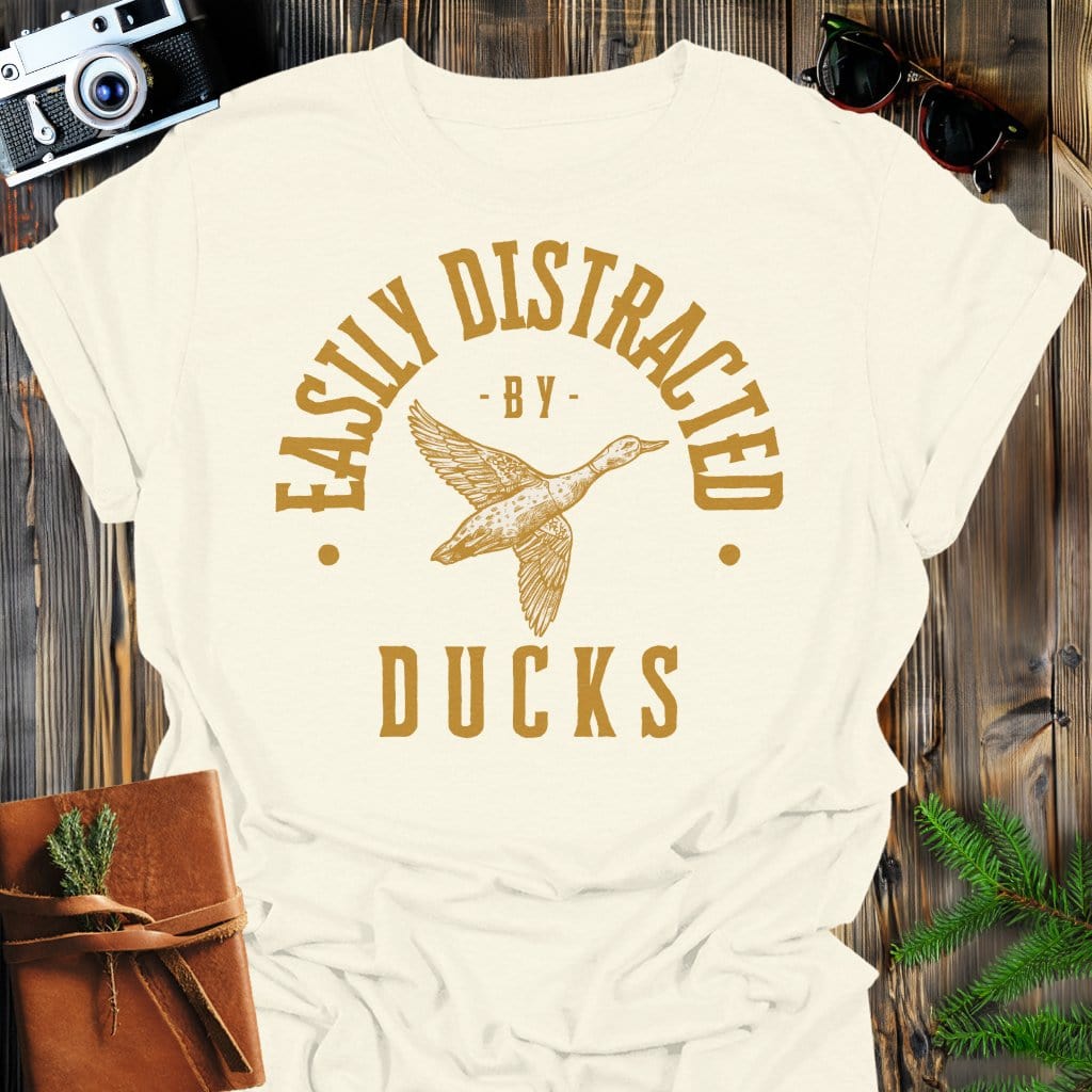 Distracted by Ducks T-Shirt In S / Natural Lightweight adventure tee for outdoor lovers Perfect for hiking camping or road trips Made from soft breathable cotton for all-day comfort Ideal for nature lovers and adventurers FAYO Threads outdoor apparel remember Fun Awaits You Outside
