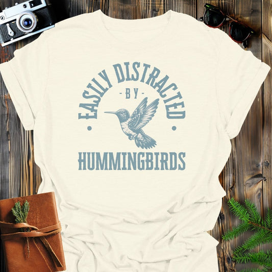 Distracted By Hummingbirds T-Shirt In S / Natural Lightweight adventure tee for outdoor lovers Perfect for hiking camping or road trips Made from soft breathable cotton for all-day comfort Ideal for nature lovers and adventurers FAYO Threads outdoor apparel remember Fun Awaits You Outside