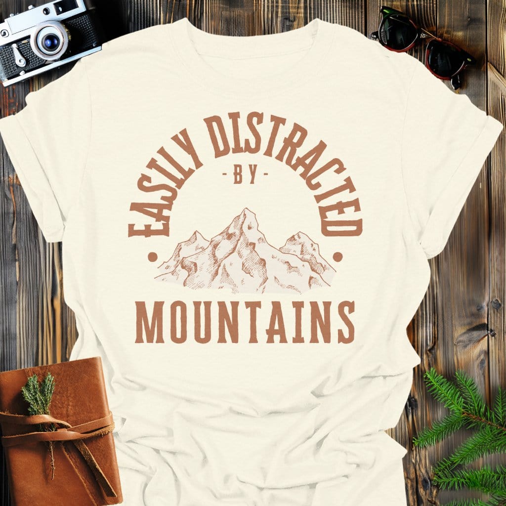 Distracted by Mountains T-Shirt In S / Natural Lightweight adventure tee for outdoor lovers Perfect for hiking camping or road trips Made from soft breathable cotton for all-day comfort Ideal for nature lovers and adventurers FAYO Threads outdoor apparel remember Fun Awaits You Outside
