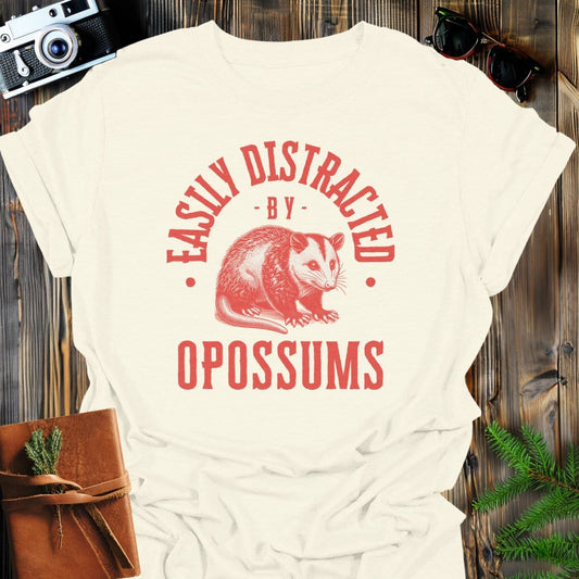 Distracted by Opossums T-Shirt In S / Natural Lightweight adventure tee for outdoor lovers Perfect for hiking camping or road trips Made from soft breathable cotton for all-day comfort Ideal for nature lovers and adventurers FAYO Threads outdoor apparel remember Fun Awaits You Outside