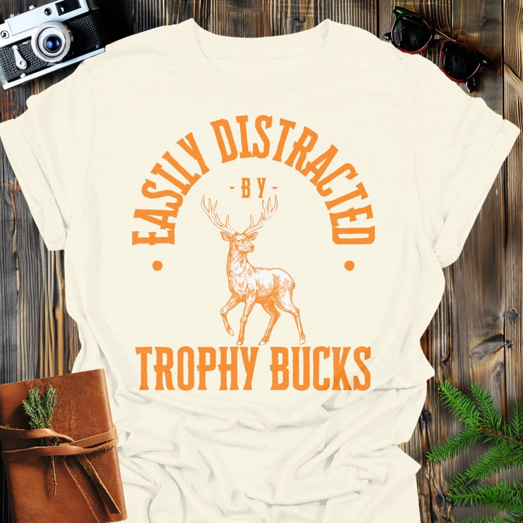 Distracted by Trophy Bucks T-Shirt In S / Natural Lightweight adventure tee for outdoor lovers Perfect for hiking camping or road trips Made from soft breathable cotton for all-day comfort Ideal for nature lovers and adventurers FAYO Threads outdoor apparel remember Fun Awaits You Outside