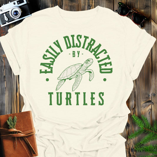 Distracted by Turtles T-Shirt In S / Natural Lightweight adventure tee for outdoor lovers Perfect for hiking camping or road trips Made from soft breathable cotton for all-day comfort Ideal for nature lovers and adventurers FAYO Threads outdoor apparel remember Fun Awaits You Outside
