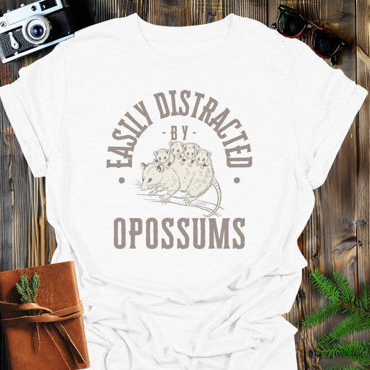 Distracted by Opossums T-Shirt In S / White Lightweight adventure tee for outdoor lovers Perfect for hiking camping or road trips Made from soft breathable cotton for all-day comfort Ideal for nature lovers and adventurers FAYO Threads outdoor apparel remember Fun Awaits You Outside