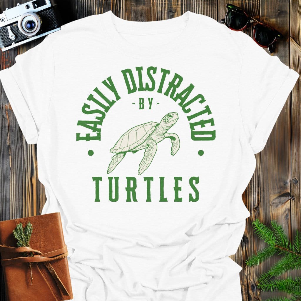 Distracted by Turtles T-Shirt In S / White Lightweight adventure tee for outdoor lovers Perfect for hiking camping or road trips Made from soft breathable cotton for all-day comfort Ideal for nature lovers and adventurers FAYO Threads outdoor apparel remember Fun Awaits You Outside