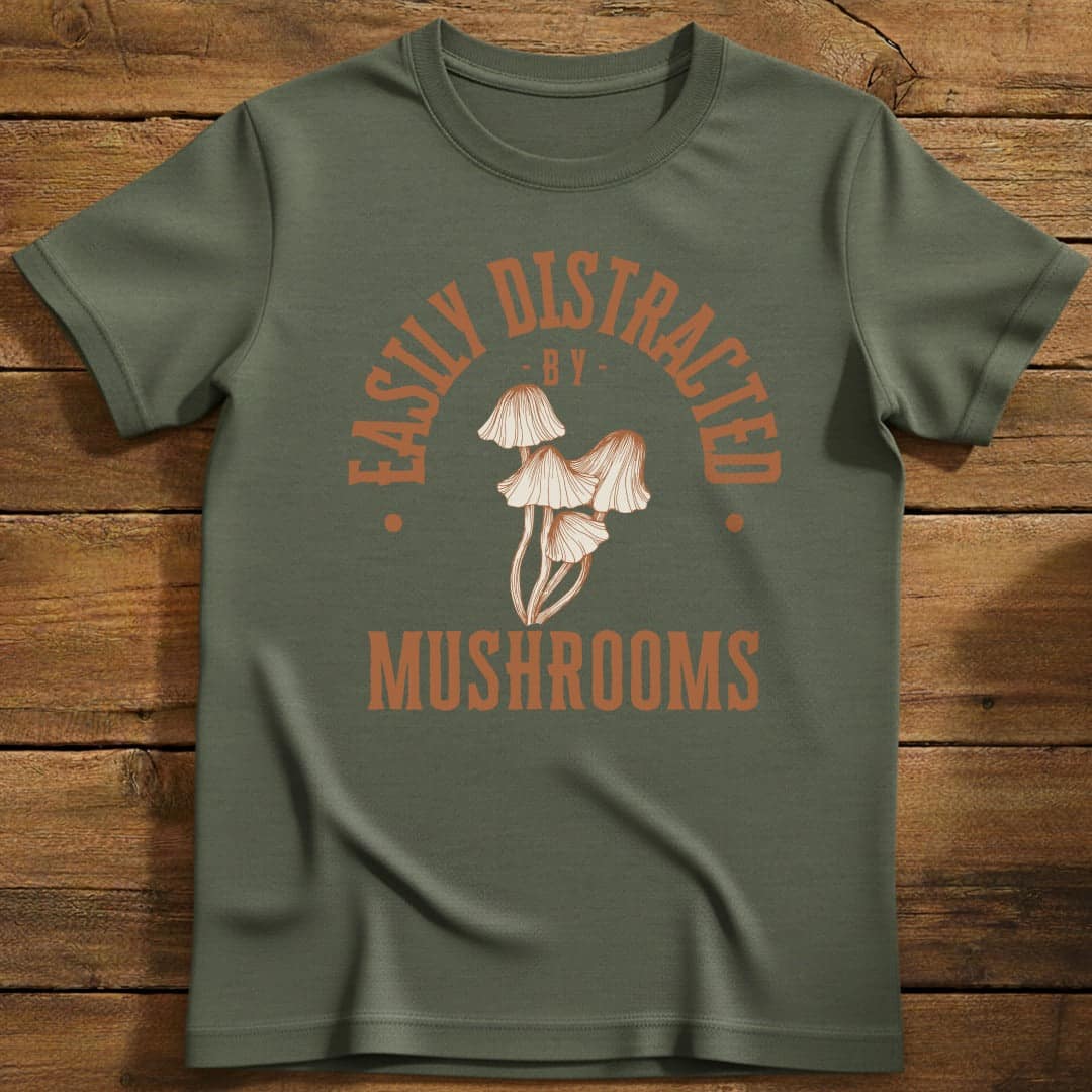 Distracted by Mushrooms T-Shirt In S / Military Green Lightweight adventure tee for outdoor lovers Perfect for hiking camping or road trips Made from soft breathable cotton for all-day comfort Ideal for nature lovers and adventurers FAYO Threads outdoor apparel remember Fun Awaits You Outside