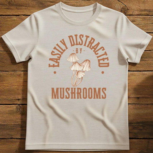 Distracted by Mushrooms T-Shirt In S / Natural Lightweight adventure tee for outdoor lovers Perfect for hiking camping or road trips Made from soft breathable cotton for all-day comfort Ideal for nature lovers and adventurers FAYO Threads outdoor apparel remember Fun Awaits You Outside